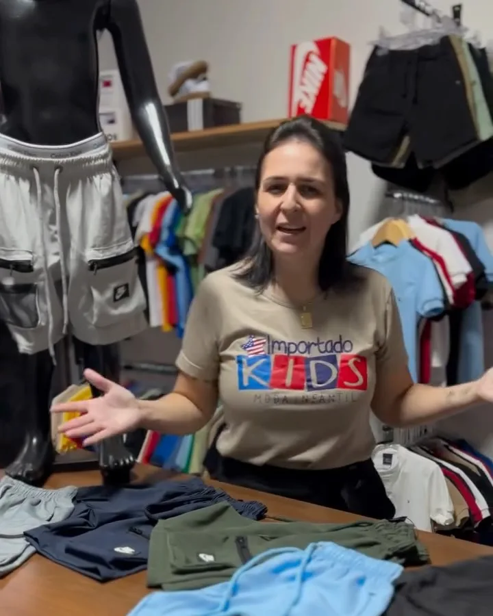 A dona da loja no balcão, com a camiseta da Importado Kids